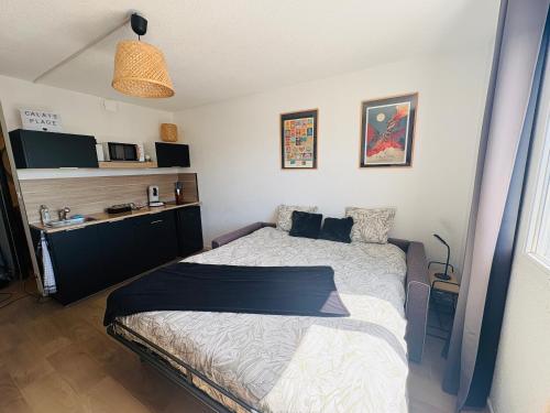 a bedroom with a bed and a desk with a microwave at Studio calais la plage in Calais