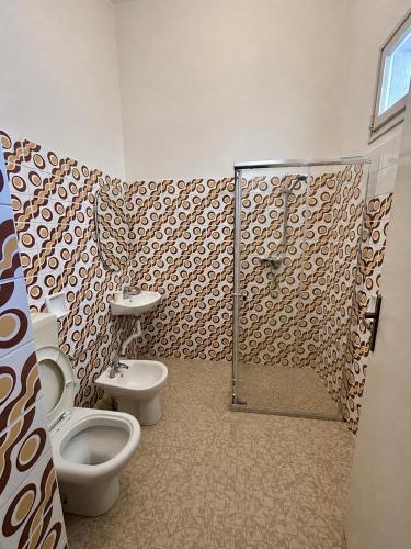 a bathroom with two toilets and a shower at Hotel Canasta in Misano Adriatico