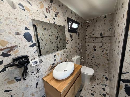 a bathroom with a sink and a phone on a counter at טריו בכרמל in Dāliyat el Karmil