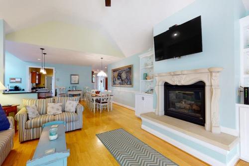 a living room with a fireplace with a tv above it at Salt Pond -- 273 Oyster Shell Cove in Bethany Beach