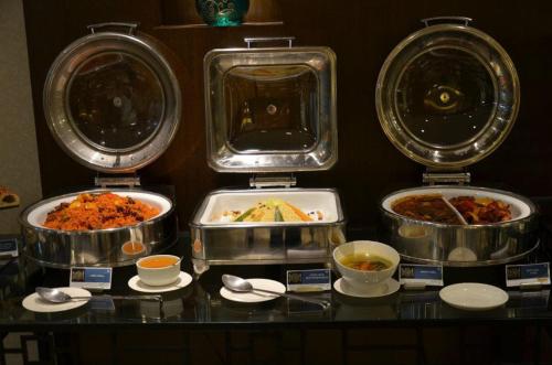 three different dishes of food in trays on a counter at Fortune Park Lake City, Thane - Member ITC Hotels' Group in Thane