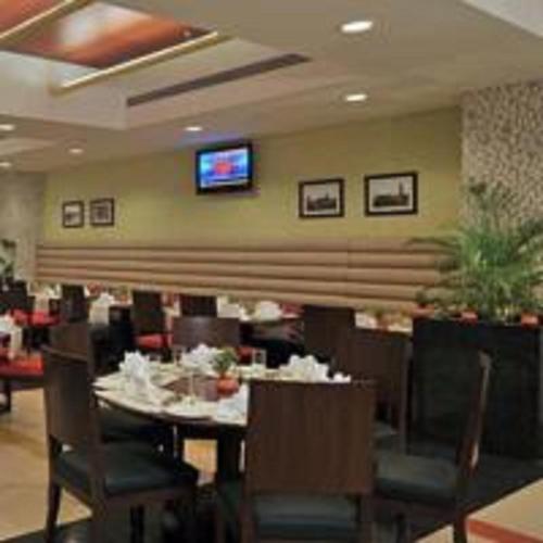 a restaurant with a table and chairs and a television at Fortune Park Lake City, Thane - Member ITC Hotels' Group in Thane