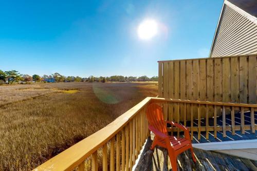 a red chair sitting on the porch of a house at Stewards Watch -- 539C Hudson in Bethany Beach