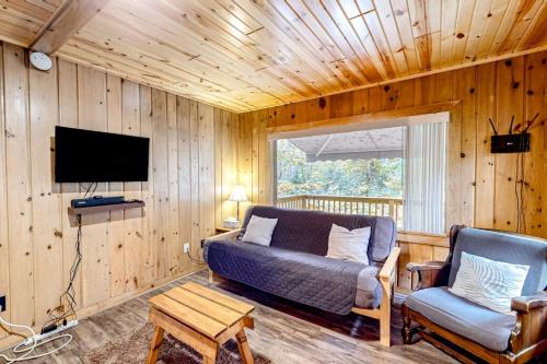a living room with a couch and a tv and a chair at Dragonfly Gully in Rhinelander