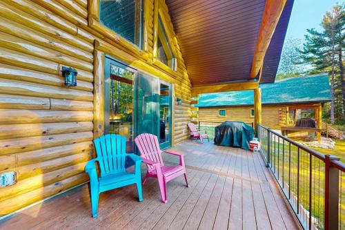 two chairs sitting on a porch of a cabin at Brown Bear Cabin in Tomahawk