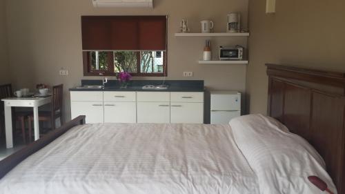 a bedroom with a white bed and a kitchen at Great Hill View Apartment in Grote Berg