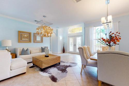a living room with white furniture and a chandelier at Villa Katrin in Naples