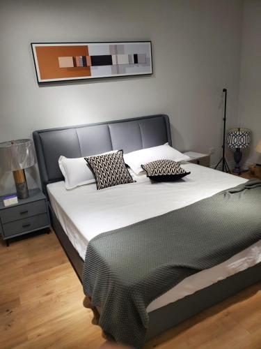 a bedroom with a large bed with black and white pillows at Vila Kastriotet-Hotel in Lezhë