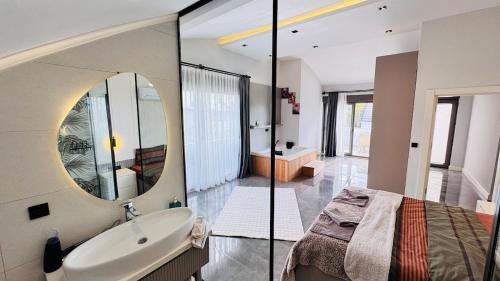 a bathroom with a bed and a sink and a mirror at Villa Maris Belek Villa in Belek