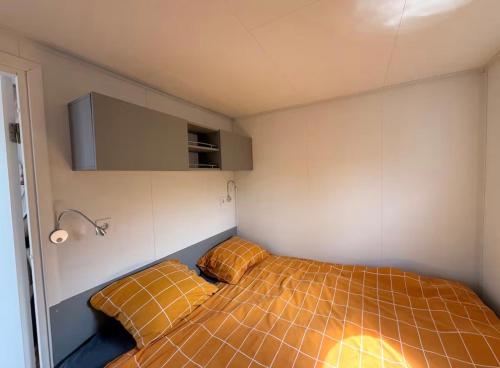a small room with a bed and two pillows at Glamping Houseboat in Dinteloord