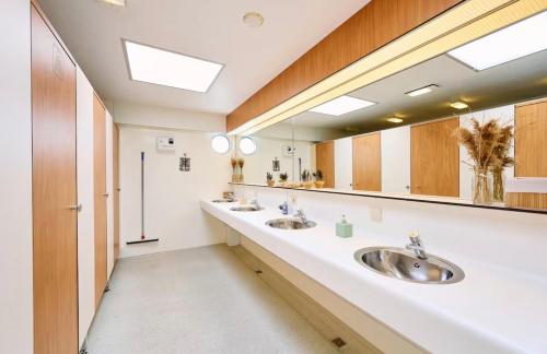 a bathroom with two sinks and a large mirror at Glamping Houseboat in Dinteloord