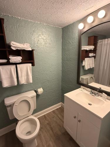 a bathroom with a toilet and a sink and a mirror at Ocean 12 Beach Hotel in Myrtle Beach