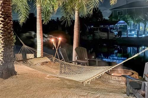 a hammock between two palm trees on a beach at Coastal Escape in Saint James City