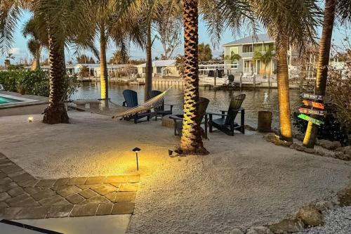 a backyard with palm trees and a hammock and a house at Coastal Escape in Saint James City