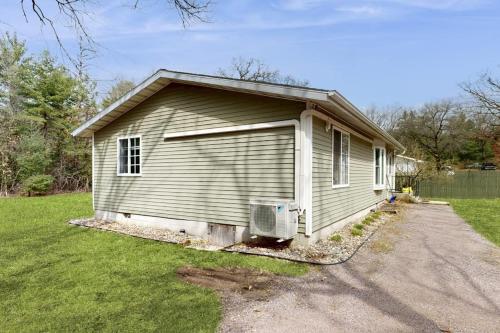 a small house with a garage in a yard at Whispering Pines in Wisconsin Dells