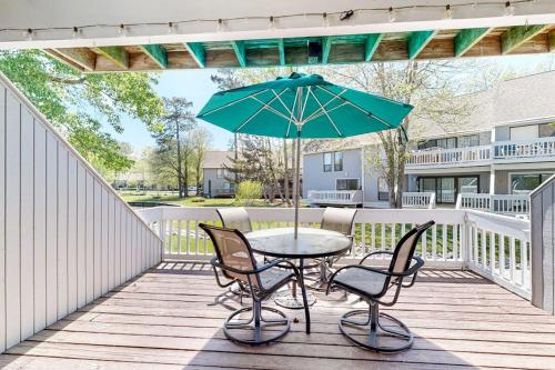 a table with chairs and an umbrella on a deck at Sea Colony --- 3404 Round Robin Way in Bethany Beach