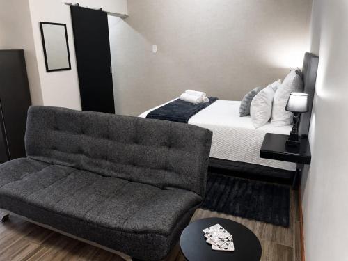 ein Wohnzimmer mit Sofa und Bett in der Unterkunft Scarlett's in Welgelegen