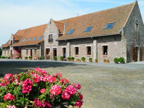 un grand bâtiment en briques avec des fleurs devant lui dans l'établissement Varlet Farm, à Poelkapelle