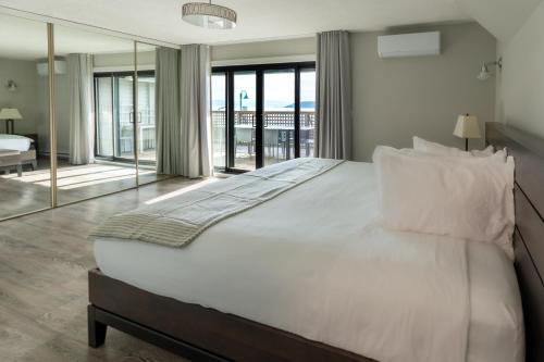 a bedroom with a large white bed with a view at Sechelt inn in Sechelt