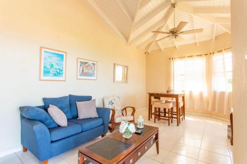 a living room with a blue couch and a table at Oceanview Terrace, Walk to Beach, WiFi and Parking in Saint Lucy