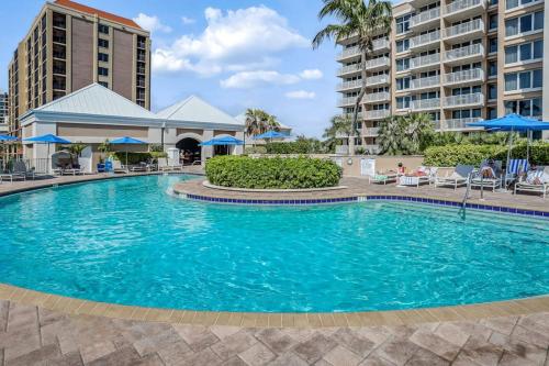 a swimming pool at a resort with chairs and umbrellas at Marco Beach Ocean Resort Condominiums #605 in Marco Island