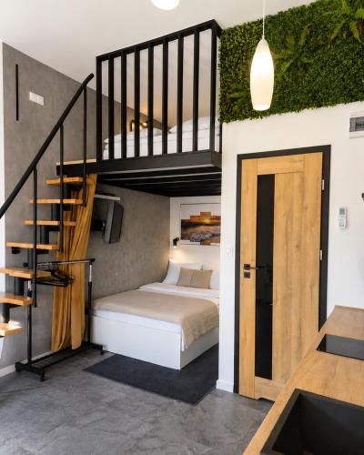 a bedroom with a bed and a stair case at MORSKI SEN-Przytulne studio z antresolą w centrum Mielna in Mielno