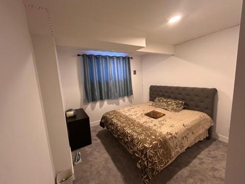 a small bedroom with a bed and a window at Havre de paix in Fort Saskatchewan