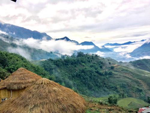 a view of a valley with mountains and huts at Sapa Clay House - Mountain Retreat in Sa Pa