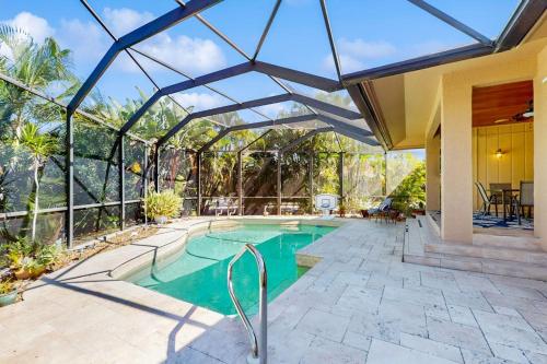 a swimming pool in a house with a glass ceiling at Tranquil Haven in Marco Island