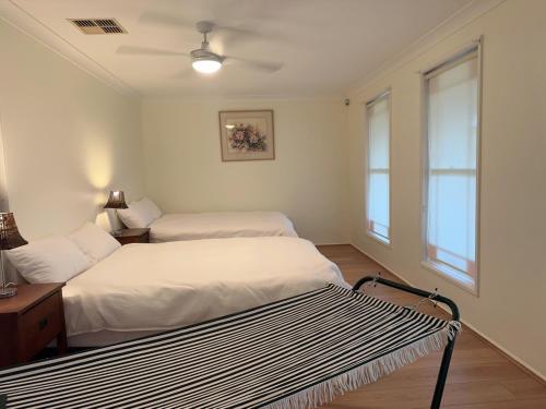 two beds in a room with two windows at Private Room-2Queen beds in Elderslie