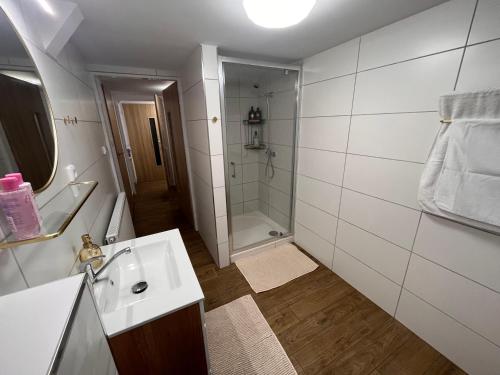 a white bathroom with a sink and a shower at Chalupa U Franze in Malá Morava