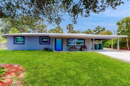 a house with a blue door and a yard at Casa Coconut in Naples