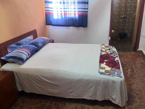 a bed with blue pillows on it in a room at Sumanya guest house 6 in Sukuta