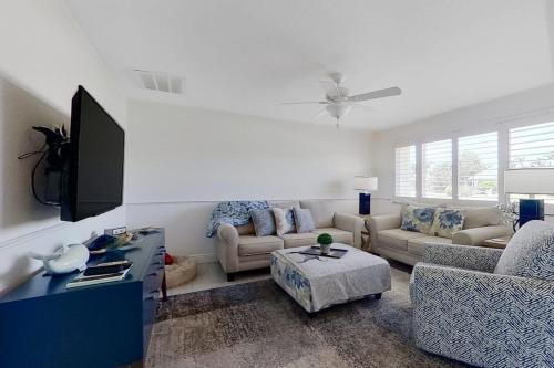 a living room with a couch and a tv at Southwest Florida Sanctuary in Cape Coral