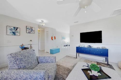 a living room with a couch and a tv at Southwest Florida Sanctuary in Cape Coral