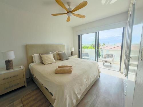a bedroom with a large bed with a ceiling fan at Penthouse In Tracadero Oceanfront Infinity Pool in La Laguna