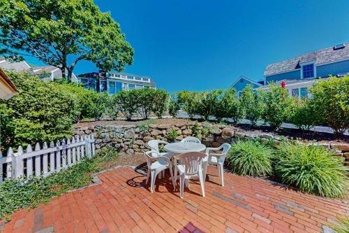 a table and chairs sitting on a brick patio at Maushop By The Sea in Mashpee