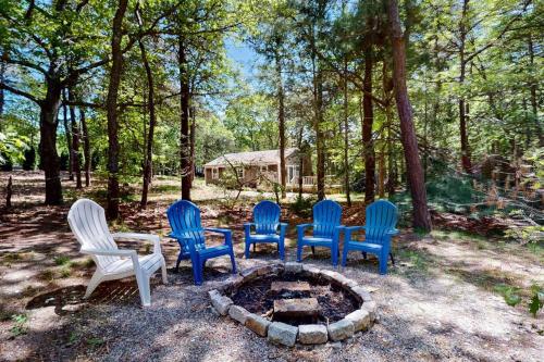 a group of chairs sitting around a fire pit at The Woodland Cottage in Eastham
