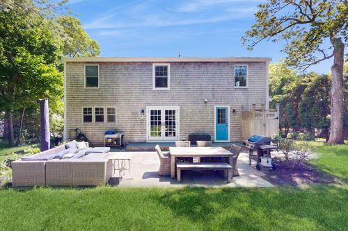 a patio with a couch and a table in front of a house at Blissful Island Haven in Oak Bluffs