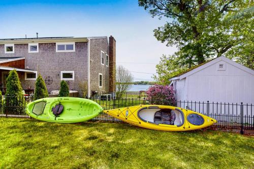 two canoes sitting on the grass next to a house at Sunset Cove Retreat in Wareham