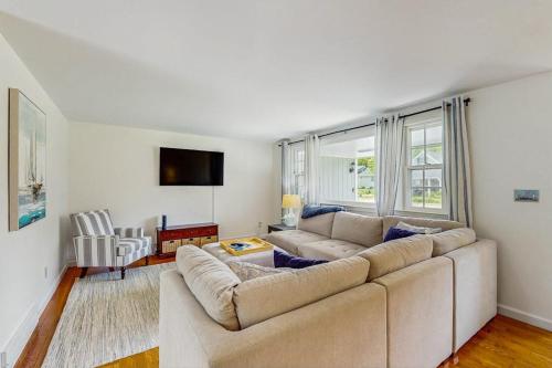 a living room with a large couch and a large window at Great Pond Escape in Falmouth