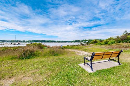 a bench sitting in the grass near a body of water at Great Pond Escape in Falmouth
