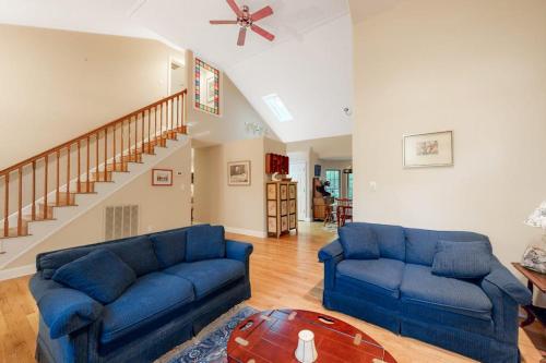 a living room with blue couches and a staircase at Beaconhill Road 68 in Ocean Pines