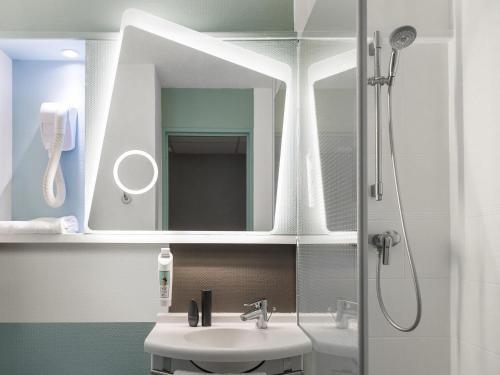 a bathroom with a sink and a mirror at ibis Longwy Mexy in Mexy