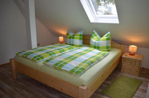 a bedroom with a bed with green and blue pillows at Ferienwohnung Gänseblümchen in Bad Wilsnack