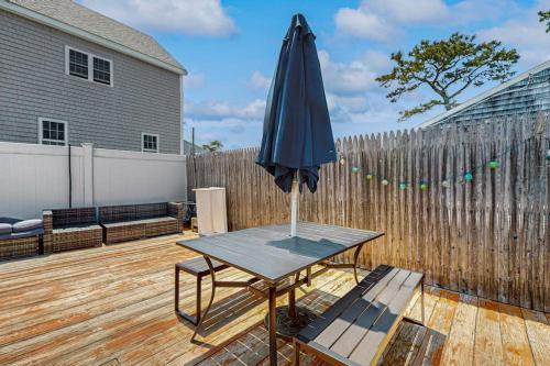 an umbrella sitting on a table in front of a fence at Glendon Beach Getaway in Dennis