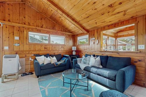 a living room with two blue couches and a table at Glendon Beach Getaway in Dennis
