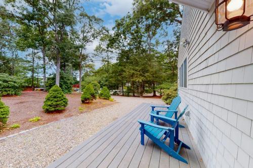 a blue bench sitting on the side of a house at Seabury Serenity in New Seabury