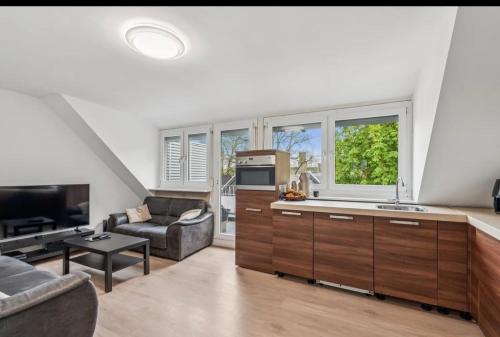 a kitchen and living room with a couch and a tv at Modern appartement nabij boulevard in Emmerich