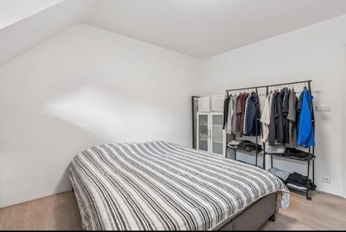 a bedroom with a bed and a rack of clothes at Modern appartement nabij boulevard in Emmerich